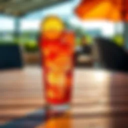 Refreshing Energy Drink A vibrant energy drink in a clear glass with ice and a slice of lemon, placed on a wooden table. The background shows a sunny outdoor setting.