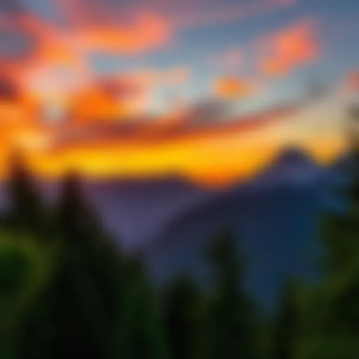 A stunning sunset view behind majestic mountains with vibrant colors in the sky and lush trees in the foreground.